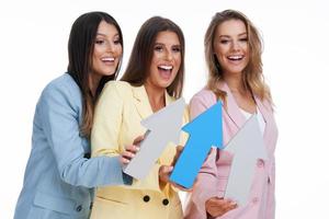 tres mujeres con trajes pastel posando con flechas sobre fondo blanco foto