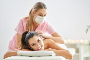 Adult woman during relaxing massage in spa photo