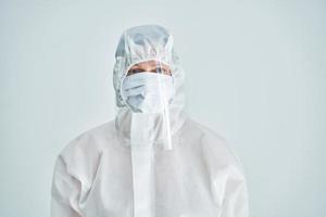 Woman in bio-hazard suit and face shield on white background. photo