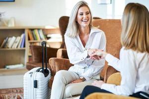 Two businesswomen greeting in modern hotel lobby photo