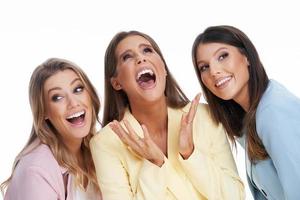 Three women in pastel suits posing over white background photo