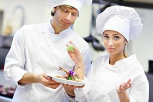 Busy chefs at work in the restaurant kitchen photo