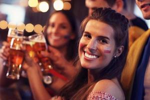 Group of friends watching soccer in pub photo