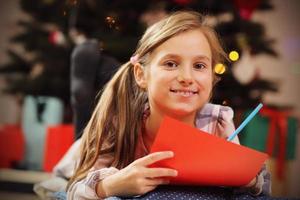 Happy Girl Writing Christmas Letter to Santa Claus photo