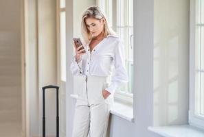 Businesswoman with luggage in modern hotel lobby photo