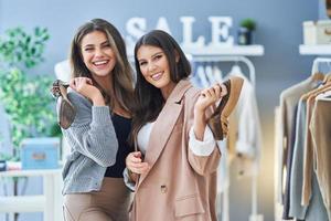 Two happy girls on shopping holding shoes photo