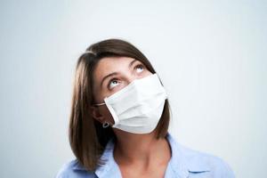 Attractive woman wearing protective mask isolated over white background photo