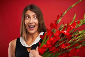 Adult woman with flowers over red background