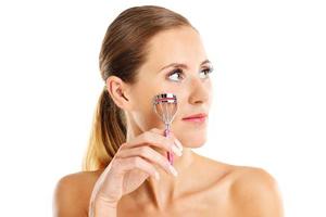 Portrait of a sensual woman with eyelash curler photo