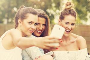 Happy group of friends with smartphones photo