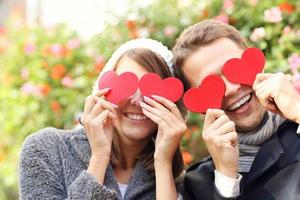 pareja feliz cubriendo los ojos con corazones foto