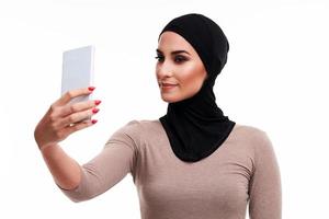 Muslim woman using smartphone over white background photo