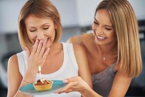 bonitas dos chicas adultas en la casa con pastel de cumpleaños foto