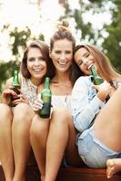 feliz grupo de amigos bebiendo cerveza al aire libre foto