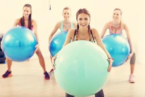Group of smiling people doing aerobics with balls photo
