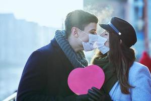 Happy couple celebrating Valentines Day in masks during covid-19 pandemic photo