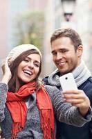 pareja joven tomando selfie en la ciudad foto