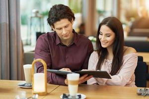 Young Couple looking at menu In Cafe photo