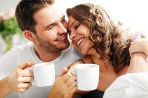 Young couple drinking coffee in bed photo