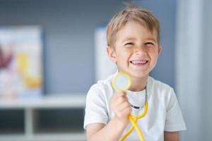 A little doctor with stethoscope smiling in doctor's office photo