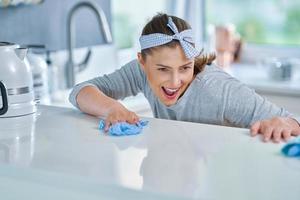 Young woman cleaning dirt in the kitchen photo