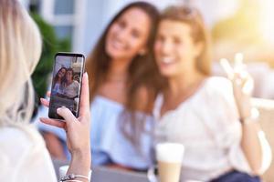 Happy girl friends hanging out in the city in summer photo