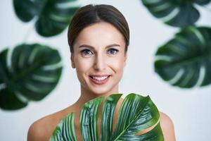 Beautiful adult woman posing against leaf background photo