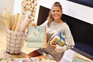 Adult woman at home wrapping Christmas presents photo