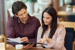 Young Couple looking at menu In Cafe photo