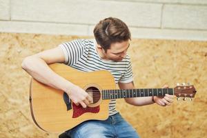 Handsome man playing guitar in studio photo