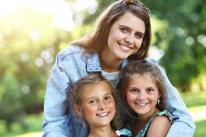 Young mom with children having fun in nature photo