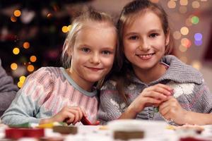 Happy little sisters preparing Christmas biscuits photo