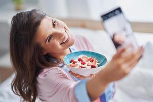 Young woman in underwear eating cereals photo
