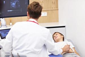 médico probando a un niño con usg foto