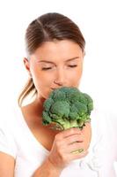 Young woman smelling broccoli photo