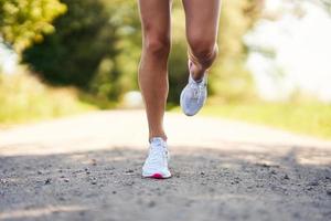 Down section of female runner jogging in the countryside photo