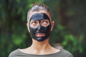 Young woman in nature with black mask on face photo