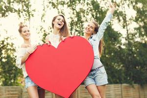 Group of women holding heart photo