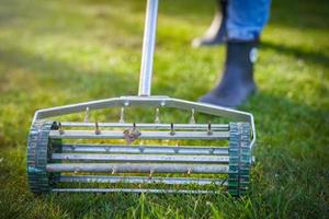 Picture of grass aerator on the green lawn photo