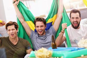 amigos varones felices animando y viendo deportes en la televisión foto