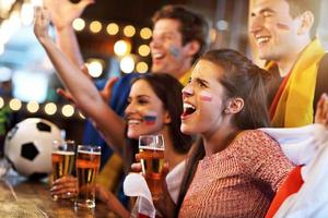 Group of friends watching soccer in pub photo