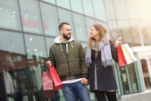 Portrait of happy couple with shopping bags after shopping in city photo