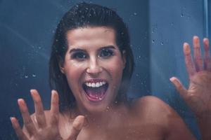 Adult woman under the shower in bathroom photo