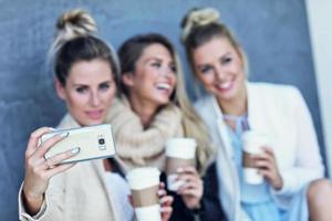 Happy group of friends taking selfie outside in autumn season photo