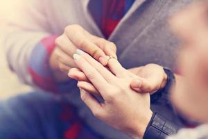 Adult man giving engagement ring to beautiful woman photo