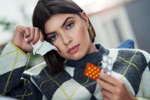 Sick teenager with pills in the living room photo