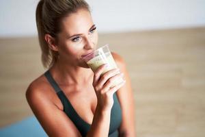 Adult woman drinking healthy smoothie after workout photo