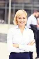 Happy businesswoman standing outside modern building photo