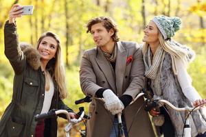 Group of friends on bikes in forest during fall time photo