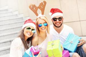 Group of friends in Santa's hats with presents photo